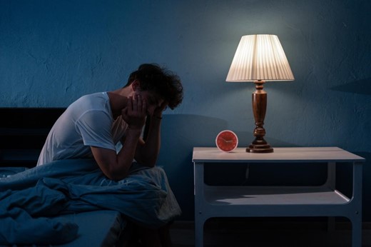 man on edge of bed